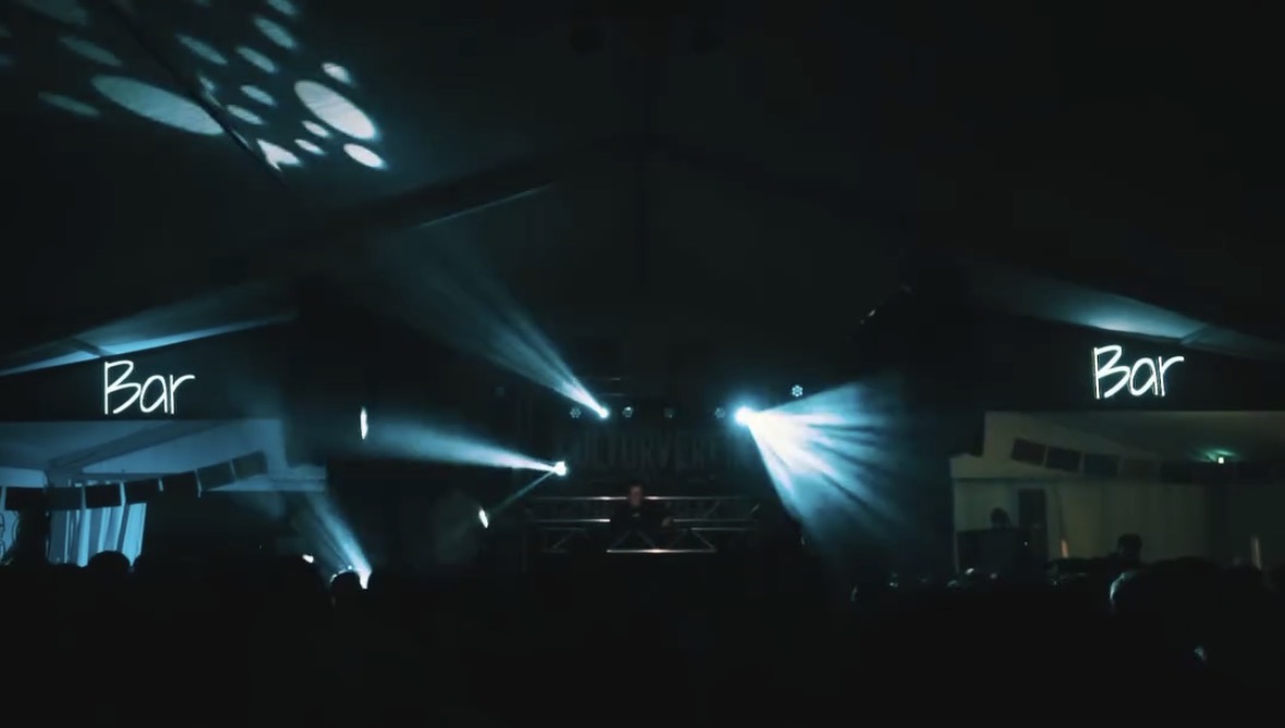 Bühne mit DJ, Lichtshow und Publikum